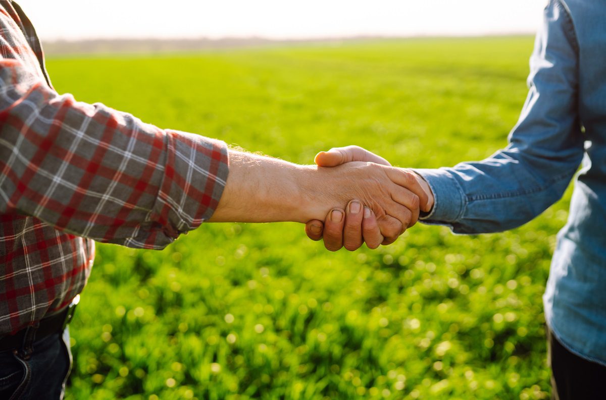 Two people shaking hands outside