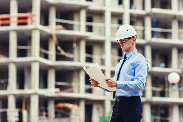 A real estate developer looking at building drawings on the site